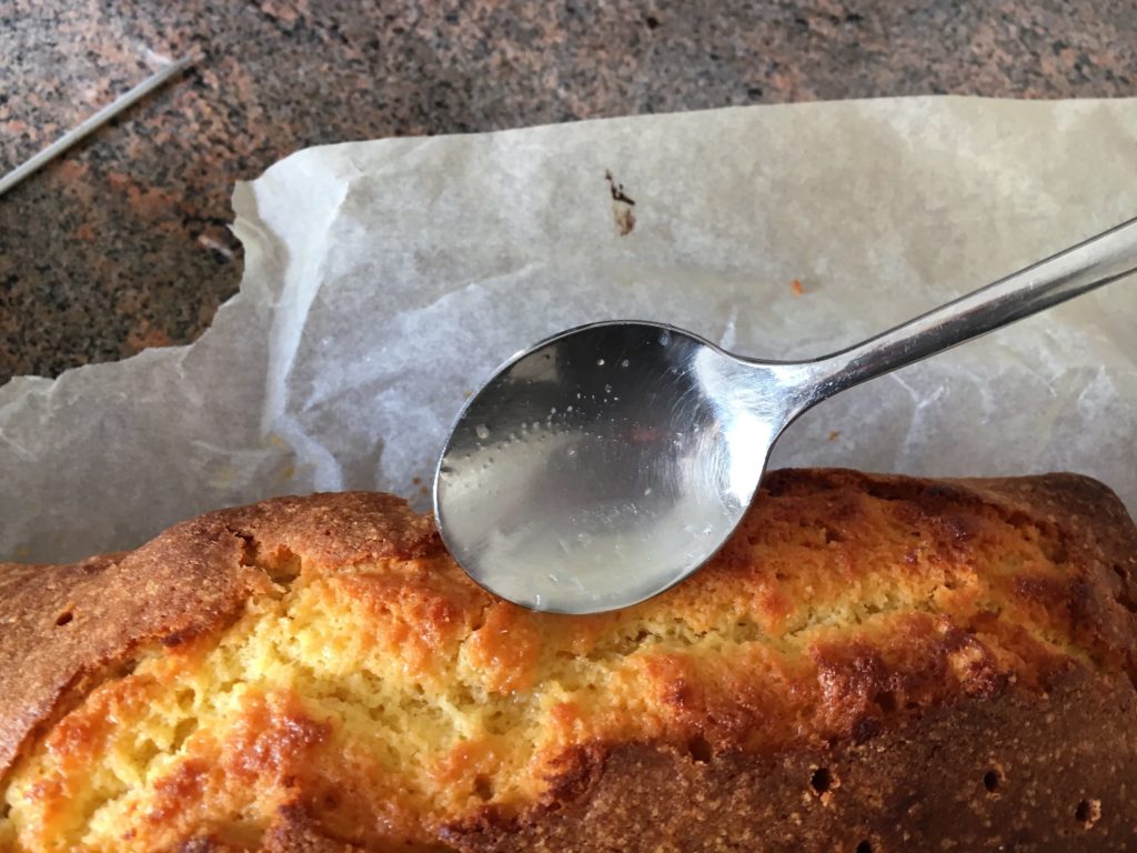 Bild den Zitronenkuchen mit Guss tränken